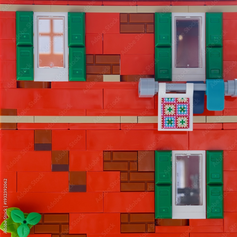 Naklejka premium Tambov, Russian Federation - January 05, 2026 Close-up of facade of red Lego building, featuring green shutters, white-framed windows.