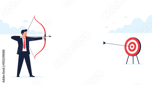 Businessman in a suit is aiming a bow and arrow at a target while another arrow has already hit the bullseye in this goal-oriented scene.