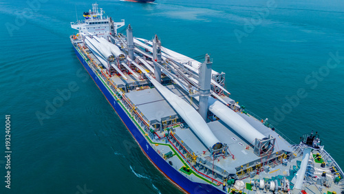 Wallpaper Mural Large heavy lift cargo ship transporting massive wind turbine blades across the deep blue ocean. Global logistics for renewable energy and maritime shipping industry business concept. Torontodigital.ca