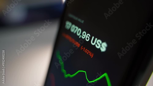 Movement of charts of falling and rising stocks and the value of the user's portfolio on the smartphone screen. Stock market fluctuations