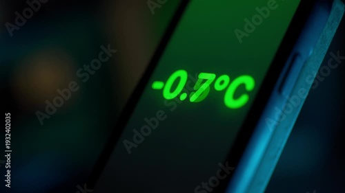 Smartphone screen shows a sharp drop in temperature in degrees Celsius