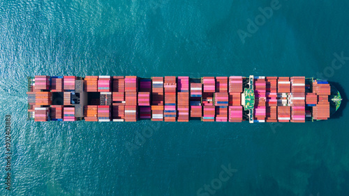 Massive container ship fully loaded with colorful freight sailing across the deep blue ocean. Global maritime logistics, international trade, and commercial shipping industry business concept.
