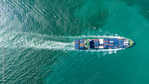 Quadro em tela arge commercial container ship loaded with colorful freight sailing across the green ocean leaving a white wake