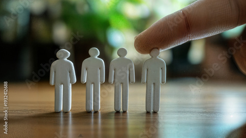 Wallpaper Mural Human finger pressing down on one white figure in a row, symbolizing a significant decision in selection or hierarchy. Torontodigital.ca