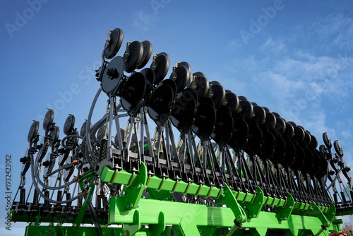 Εκτύπωση καμβά A large green seed drill folded against a cloudy sky.
