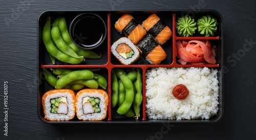 Japanese bento box with sushi, rice, and edamame.