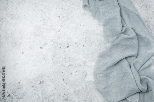 Light gray concrete background with soft blue linen fabric on the side. Top view. For food photography and product placement.