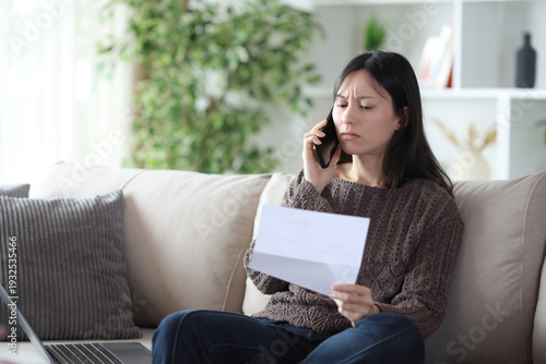 Φωτογραφία Annoyed asian woman calling on phone about letter