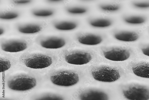Eva rug shows a pattern of holes in a gray surface used for flooring