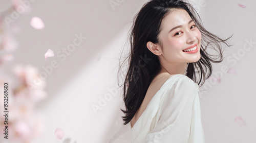 美しい肌の女性と桜が舞う春の背景