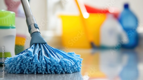 Blue Mop Head on Floor with Cleaning Supplies.