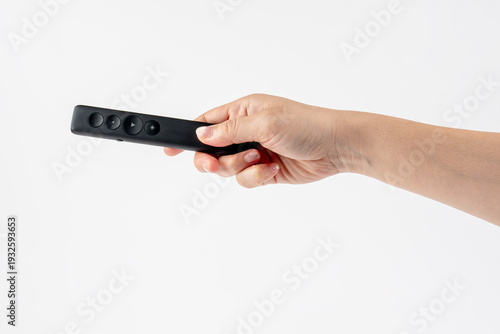 Wallpaper Mural A small black remote control in a hand, against a white background. Torontodigital.ca