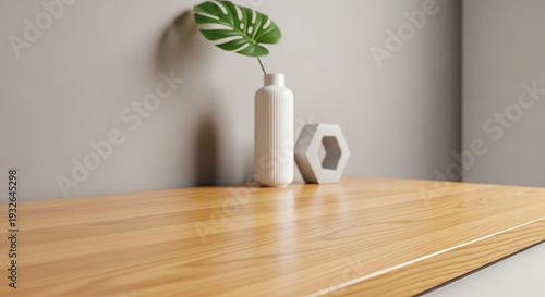Empty wooden table top with blurred background of a white bottle and a green leaf.