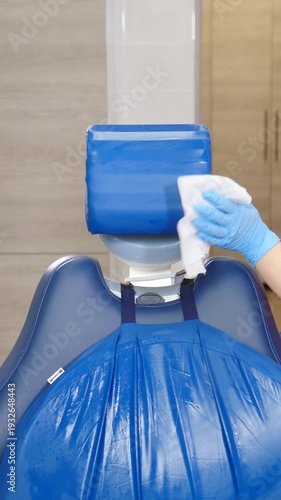 Medical nurse cleaning and disinfecting dental cabinet. Equipment being cleaned by assistant in modern dental clinic. Preparing dental office before treating patients. Vertical footage. 4 k video