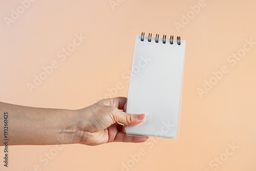 Wallpaper Mural A white notebook in hand against a cream background. Torontodigital.ca