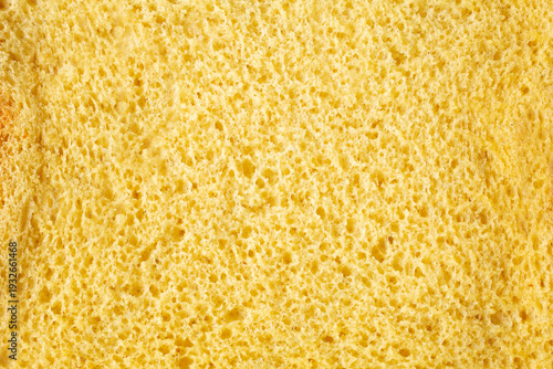 A top down view of a slice of dairy-free, gluten-free brioche bread, as a background.