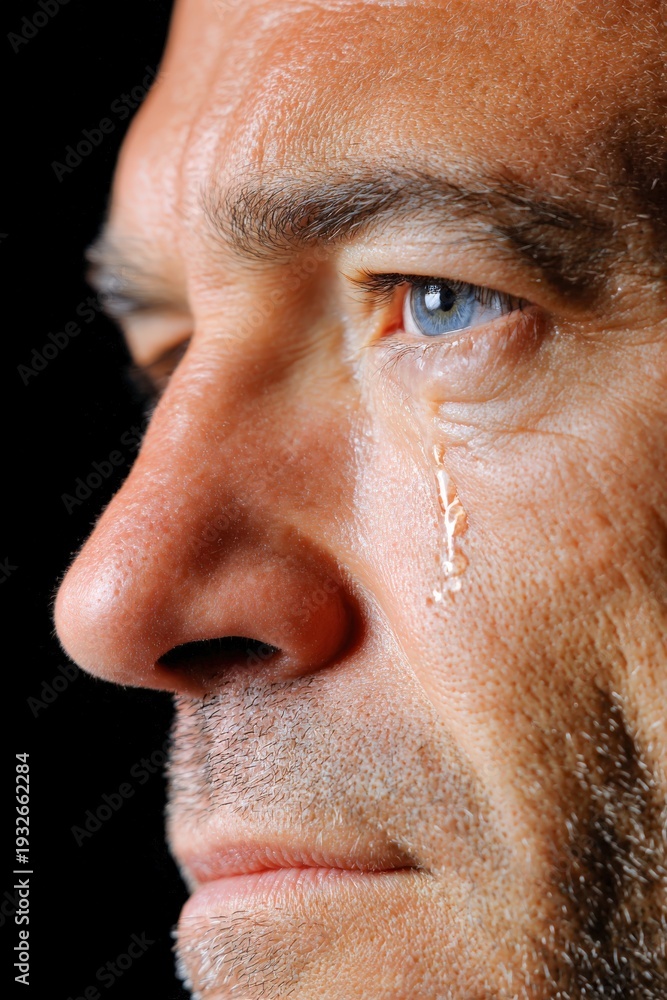 Fototapeta premium Men expressing deep emotion with a tear falling softly