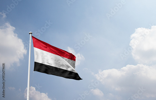 Foto Yemen national flag waving in sky.