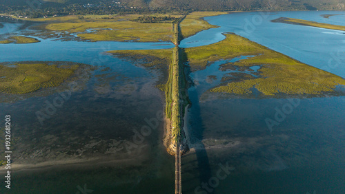 Aerial view of a strip of land dividing the tranquil waters, a serene blend of blue and green, where nature's artistry paints a vivid landscape, Knysna, Western Cape, South Africa.