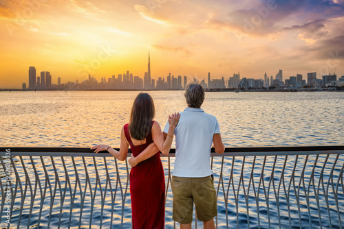 Photography A romantic tourist couple looks at the distant skyline of Dubai, UAE, during a b