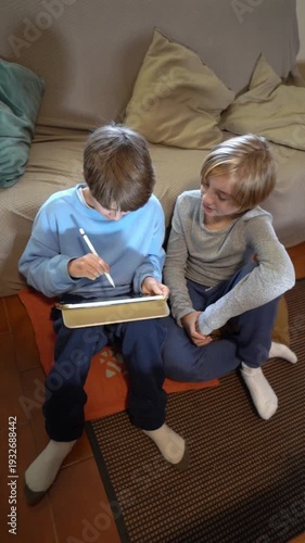 Two brothers drawing together on a digital tablet