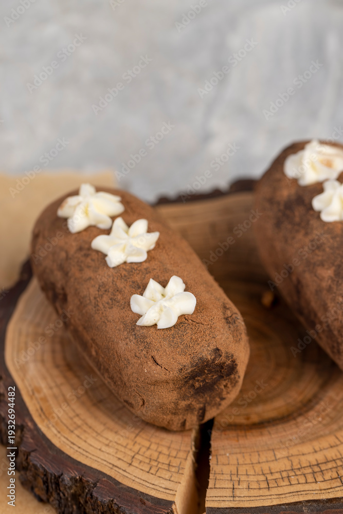 Fototapeta premium a black potato cake lies on a serving paper, a sweet classic cake made from butter and a large amount of cocoa mixed with sponge cake and cognac