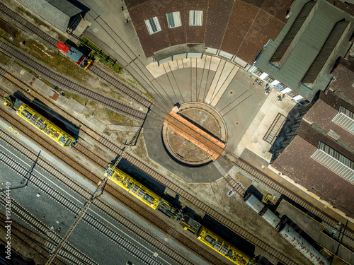 Aerial view of a circular train repair station with multiple tracks converging near a train station, Chiasso, Ticino, Switzerland.