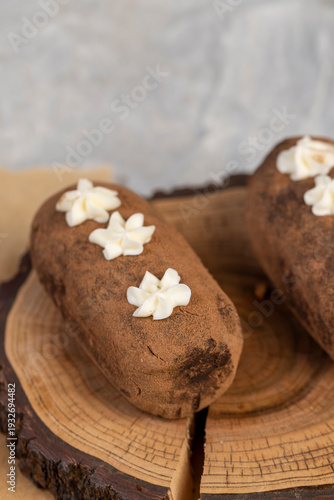 a black potato cake lies on a serving paper, a sweet classic cake made from butter and a large amount of cocoa mixed with sponge cake and cognac