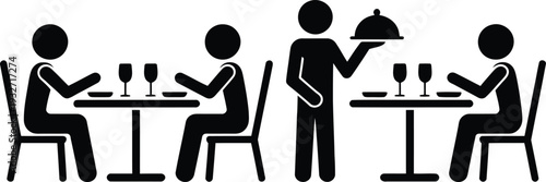 A waiter serving food to customers seated at tables in a restaurant