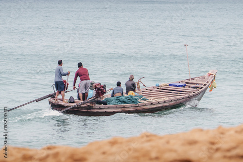 Obraz na płótnie Traditional Thai Asian fishing boat with fishermen on a coastal fishing trip in the afternoon