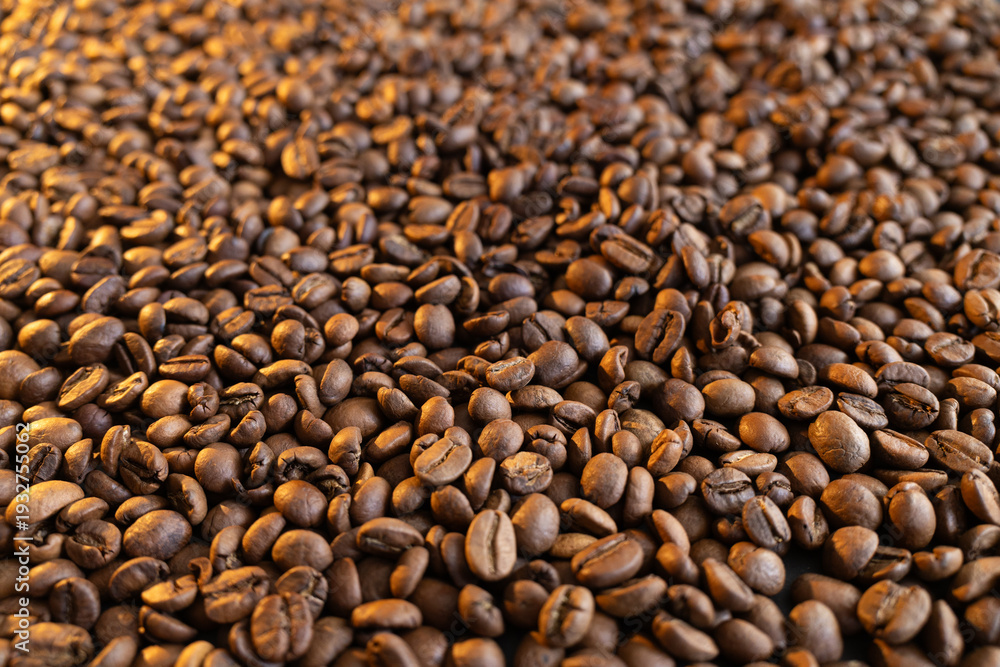 Fototapeta premium Close-up macro shot of roasted coffee beans with warm lighting creating a rich texture