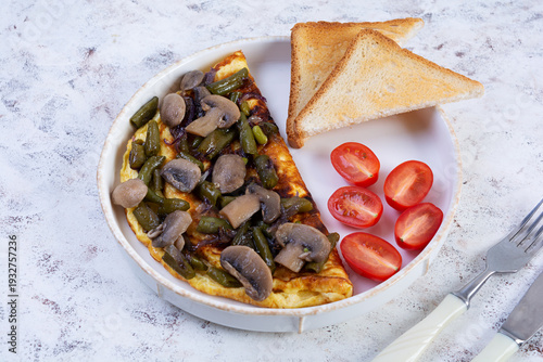 Omelette with mushrooms and green beans served with toast and cherry tomatoes