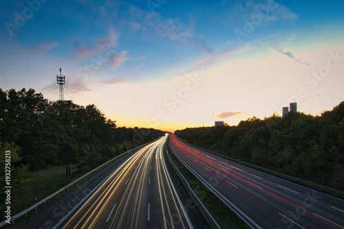 Long exposure of highway traffic at night on the A10 Berlin Ring near Dahlewitz, showing white and red car light trails and overhead road signs towards Dresden and Berlin-Tempelhof