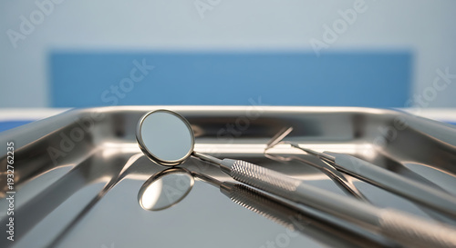 Close-up of Dental Tools on Stainless Steel Tray Including Mirror and Forceps in Professional Setting