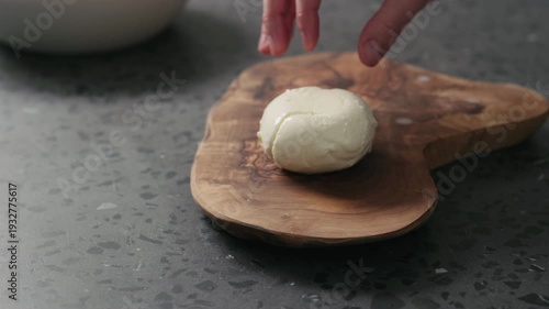 Wallpaper Mural Closeup slow motion man slicing fresh mozzarella on olive board Torontodigital.ca
