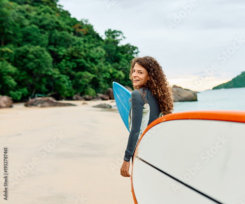 Photography Portrait of a young woman surfing at the beach, holding surfboard, ocean waves,