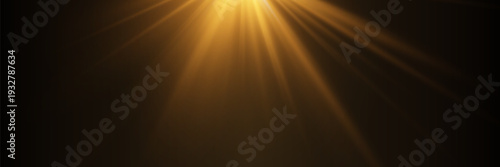 Golden light rays shining from top corner on dark black background
