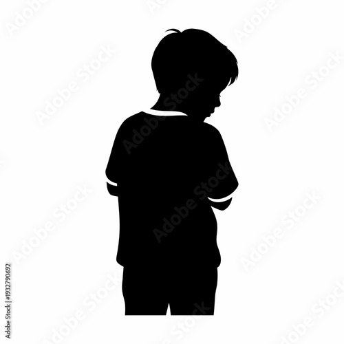 Silhouette of a young boy standing alone.
