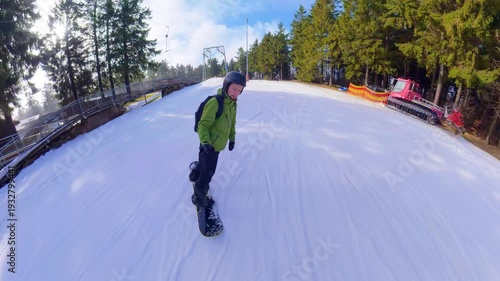 Snowboarder riding on ski slope in winter mountain resort