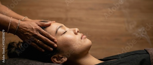 Asian woman receiving head massage with closed eyes, serene relaxation, and aromatherapy smoke in a spa setting Wellness, selfcare, and holistic therapy concept