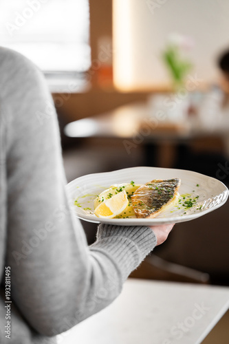 Canvas Print Plated pan-seared sea bass fillet with crispy skin, served with potatoes and fre