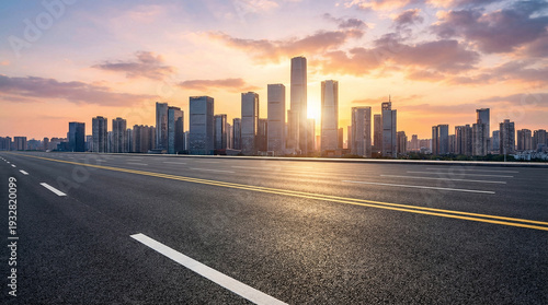 City skyline with a sun setting in the background. The sun is low on the horizon, casting a warm glow over the buildings