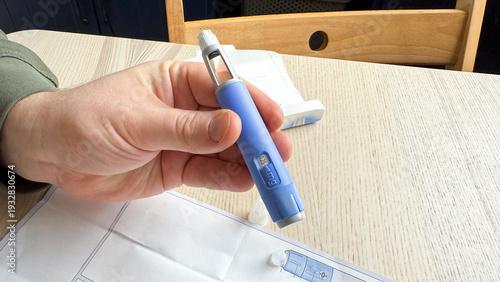 Fotografía Hand  Ozempic GLP -1  elegantly clasped around a cobalt insulin pen, World Diabe