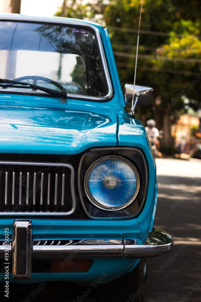 Fototapeta premium Front View of Blue Vintage Car with Classic Headlight and Grill