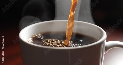 Coffee being poured into a white ceramic cup.