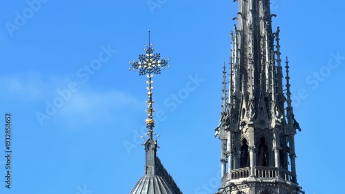 New restored cross at the top of Notre-Dame de Paris cathedral with the spire on the background in France