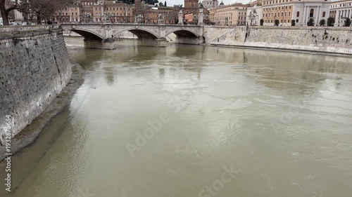 the iconic Tiber River that flows through the bridges of the city of Rome