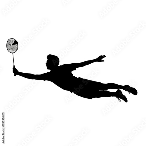 Silhouette of a badminton player diving to hit the shuttlecock during a match.