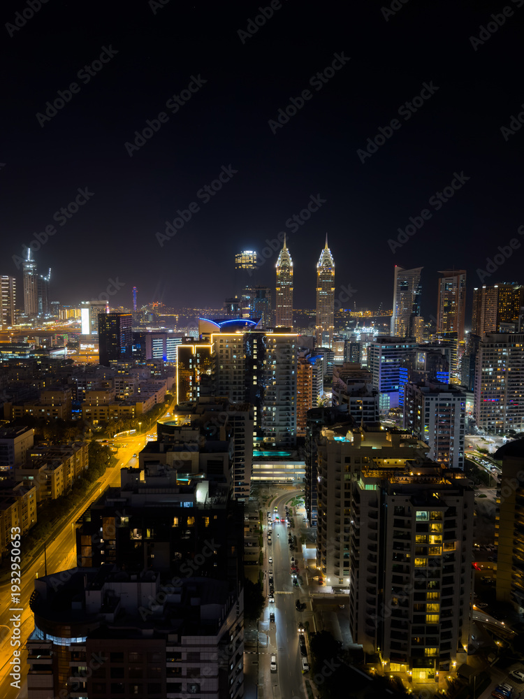 Fototapeta premium Fantastic nighttime skyline of a big city with illuminated skyscrapers, Dubai financial district at night, United Arab Emirates, aerial view.