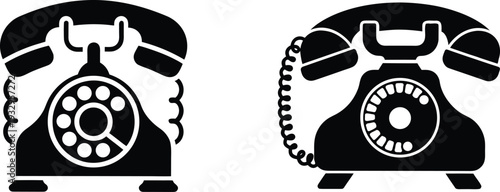 Two black and white vintage rotary telephones with coiled cords and circular dials